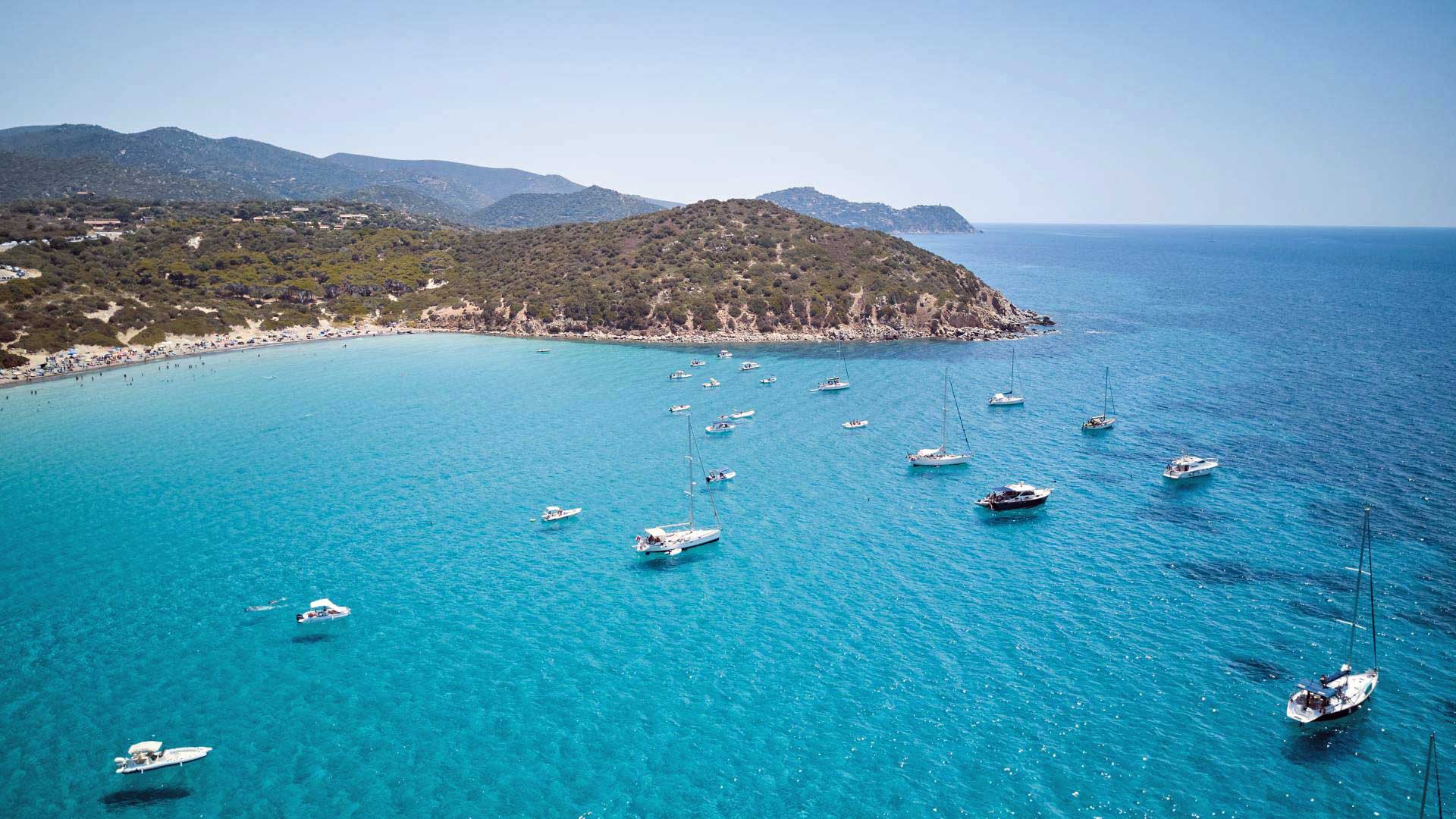 La baie de Mari Pintau vue d'en haut, avec les bateaux au mouillage sur l'eau turquoise