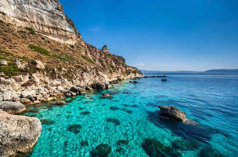 Les falaises calcaires de la Sella del Diavolo tombant dans l'eau turquoise